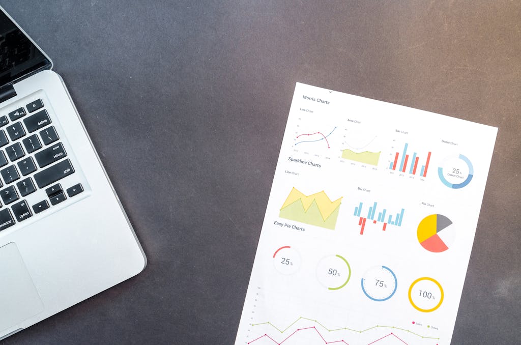 Modern desk setup with a laptop and analytical charts showcasing data interpretation and business analysis.